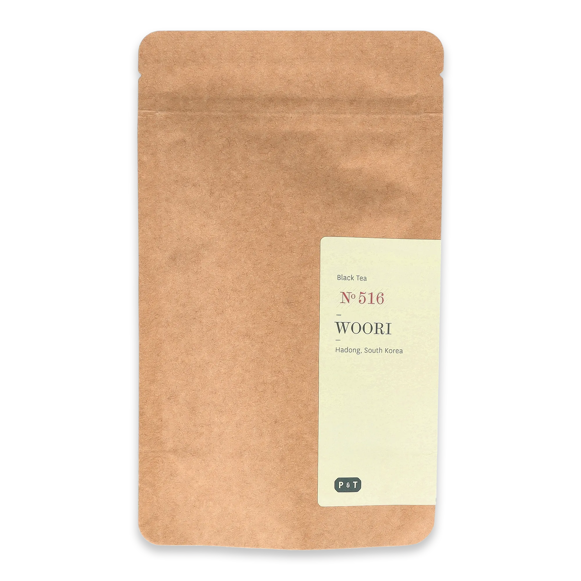 Naturbraune, wiederverschließbare Verpackung mit cremefarbenem Etikett für WOORI Black Tea No. 516 aus Hadong, Südkorea.