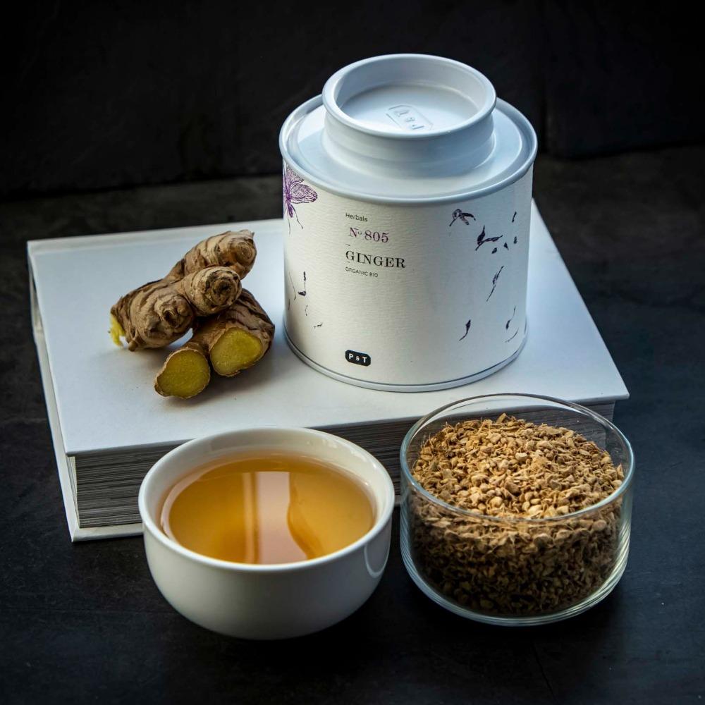Weißer runder Teebehälter 'Herbals N ° 805 P & T', frischer und getrockneter Ingwer, Keramikbecher mit Ingwertee.