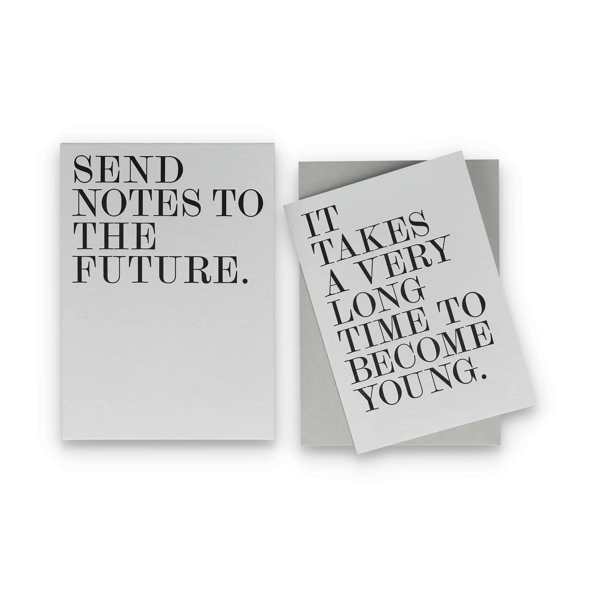 Zwei Papierschnipsel mit Serifenschriften: 'SEND NOTES TO THE FUTURE.' und 'IT TAKES A VERY LONG TIME TO BECOME YOUNG.'