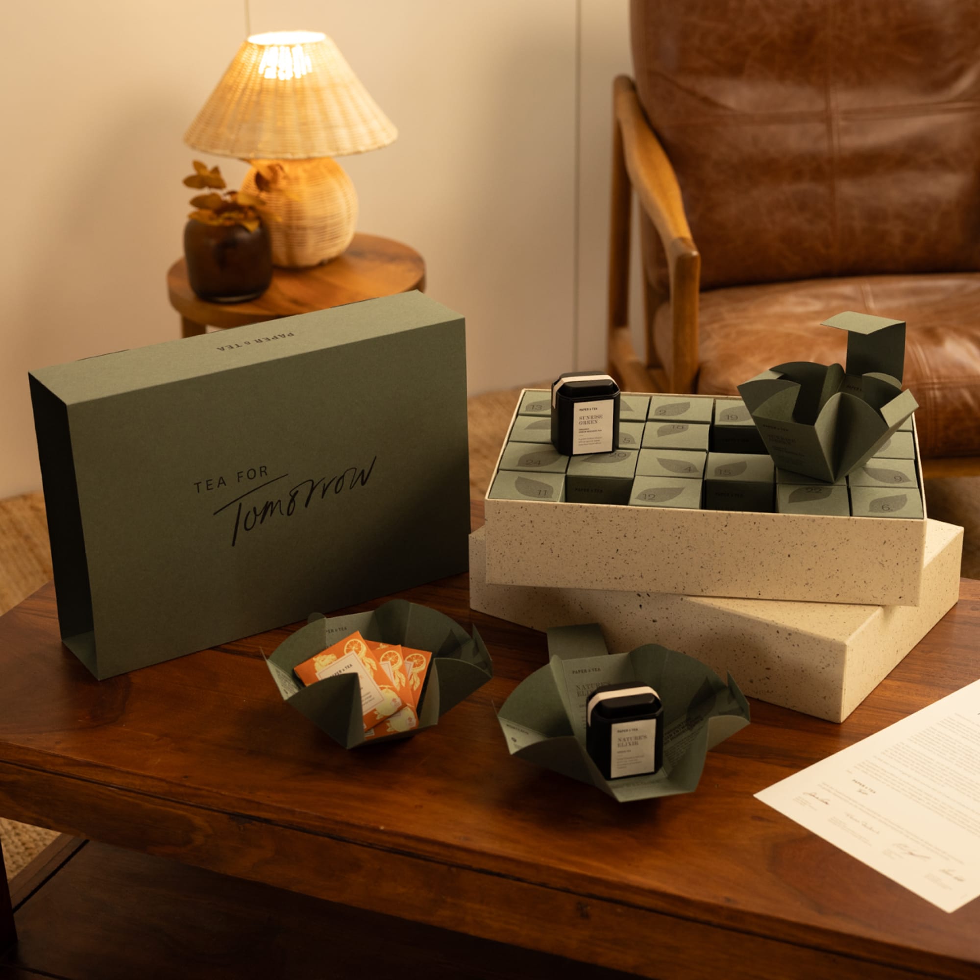 Holztisch mit TEA FOR Tomorrow Geschenkbox, Teekuben und SUNRISE GREEN Teedose.