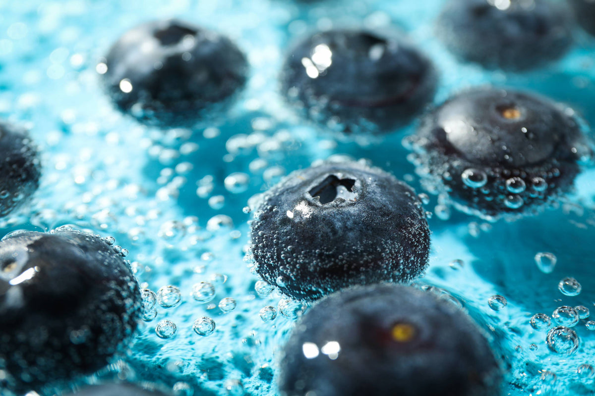 Frische Blaubeeren in einem lebendigen, sprudelnden Wasser