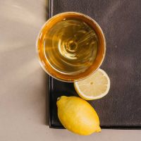Von oben gesehene Tasse goldgelben Tees mit Zitrone auf dunklem Untergrund, für frische Teepause mit P&T.